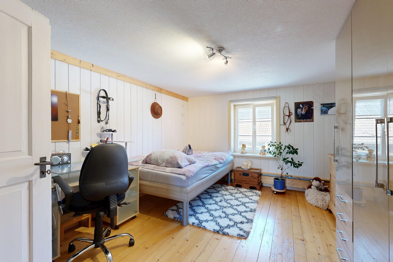 chambre avec sol en finition bois, wood finish floor, inside property, lumière naturelle, et natural light
