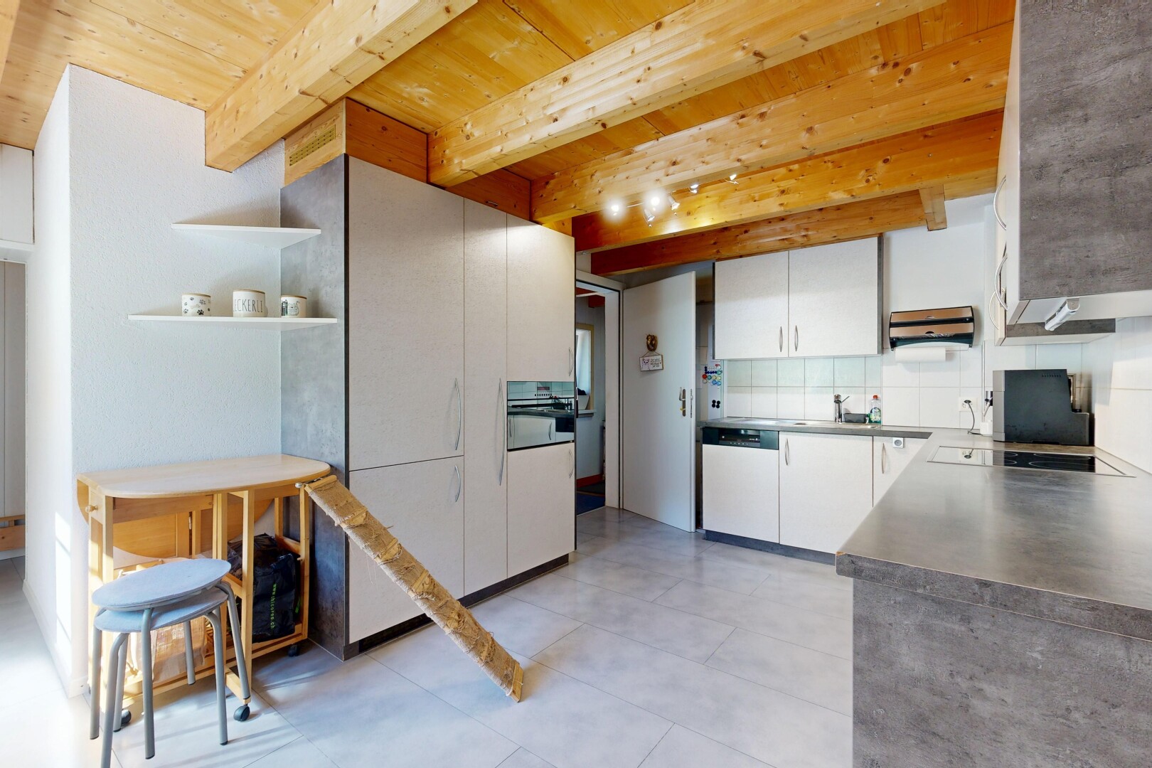 cuisine avec beamed ceiling, plafond à poutres, backsplash, dosseret, et armoires blanches