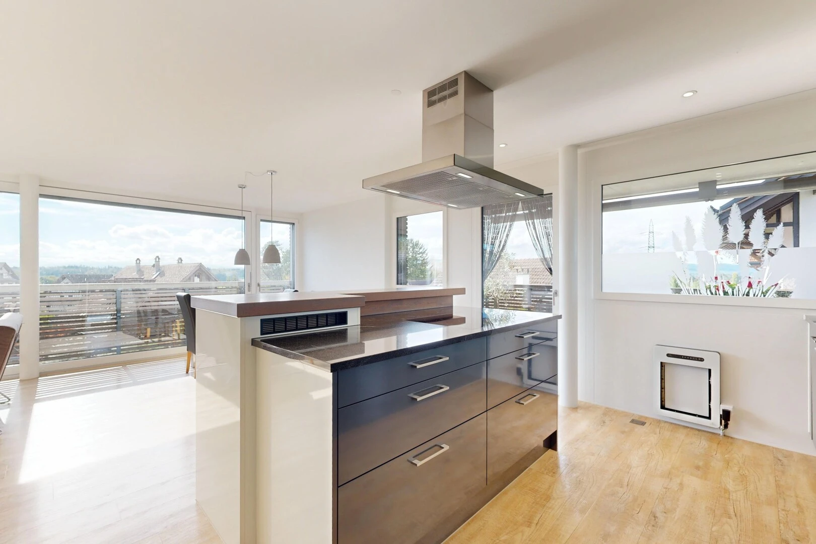 küche mit two heights countertops, arbeitsplatten, dark countertops, dunstabzugshaube, und light floor