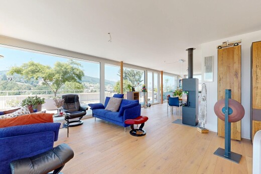 living room featuring a wood stove, light wood-style flooring, and expansive windows