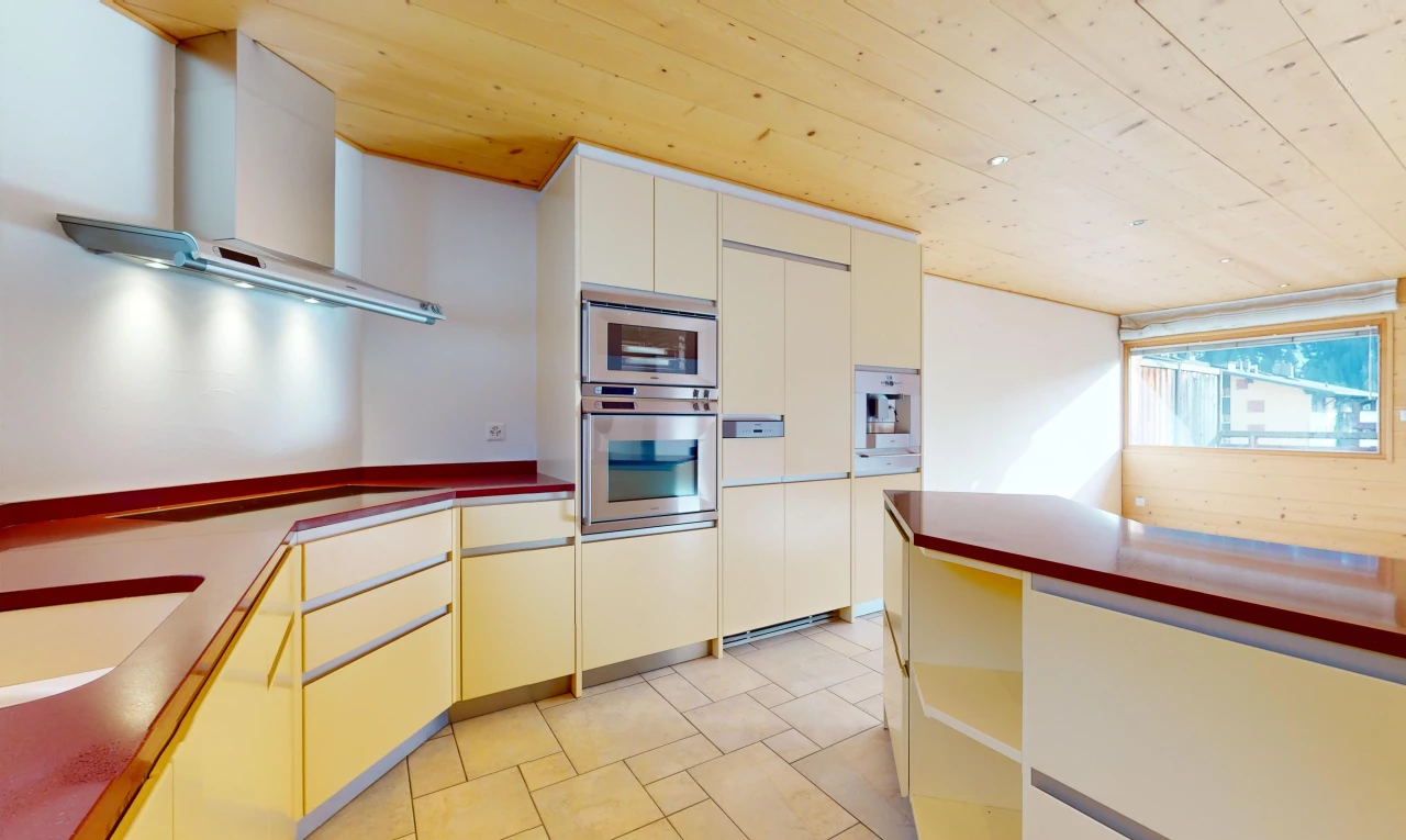 kitchen with stainless steel double oven, stovetop, light tile flooring, wall chimney range hood, and wooden ceiling