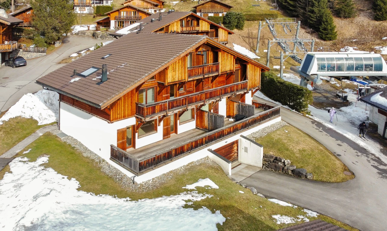 snow covered house featuring a balcony