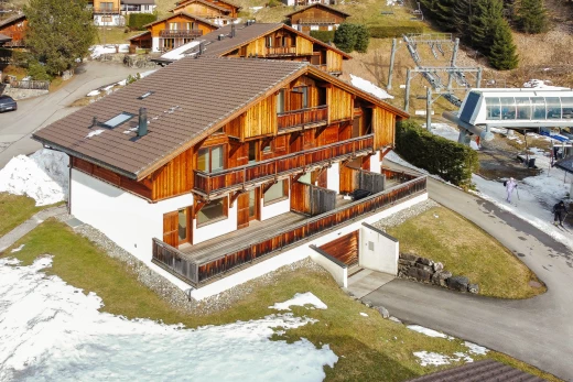 snow covered house featuring a balcony