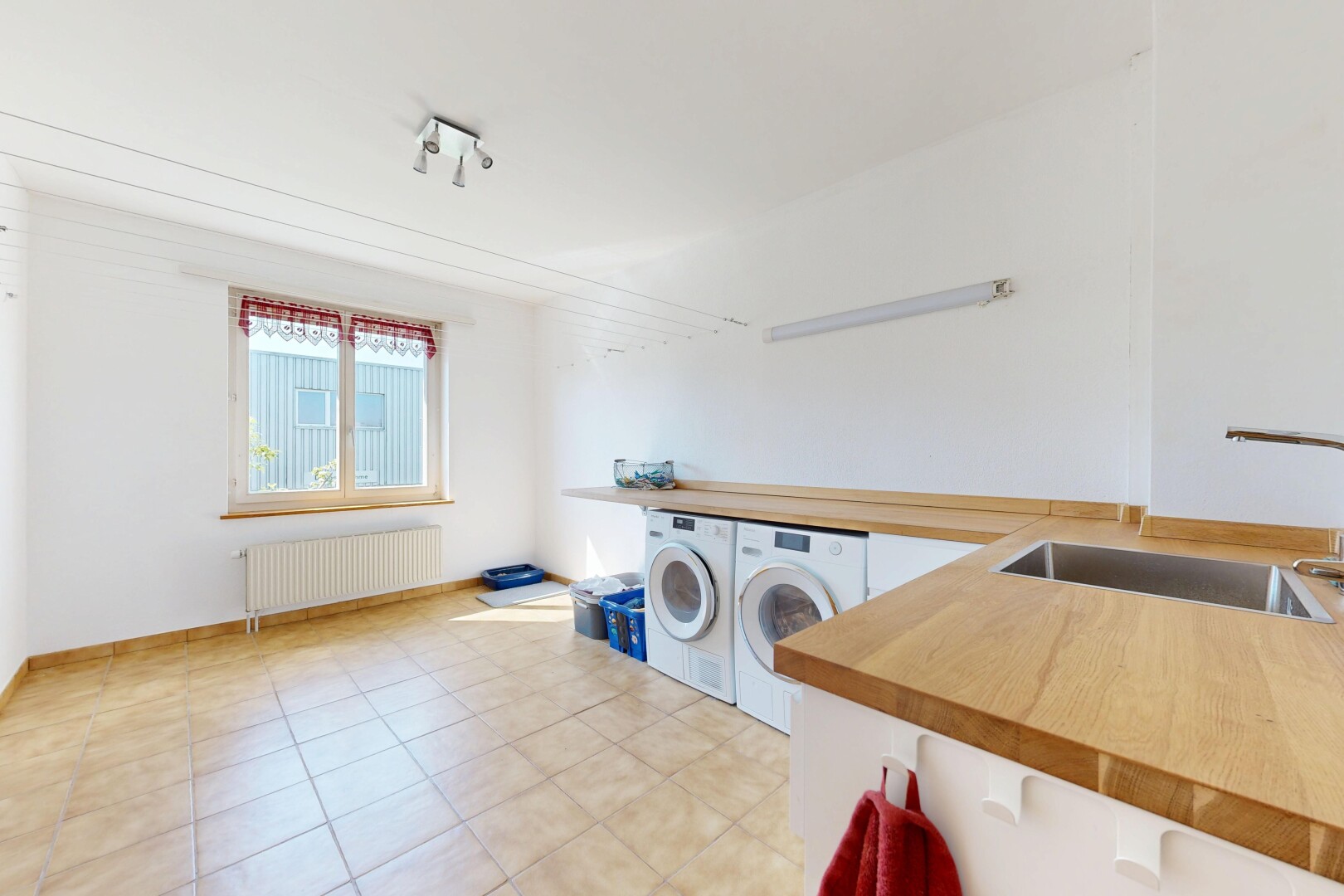 buanderie avec évier, cloison sèche, drywall, lave-linge et sèche-linge séparés, et radiateur