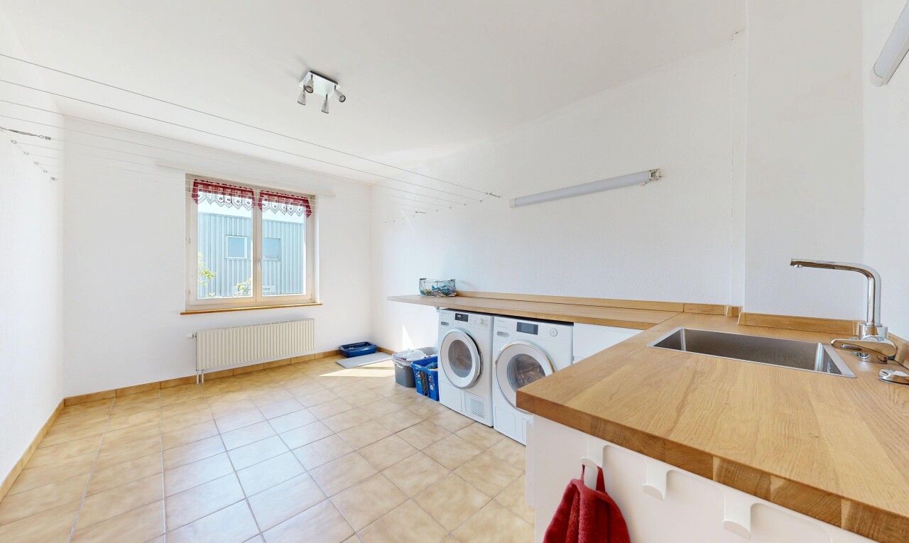 buanderie avec évier, cloison sèche, drywall, lave-linge et sèche-linge séparés, et radiateur