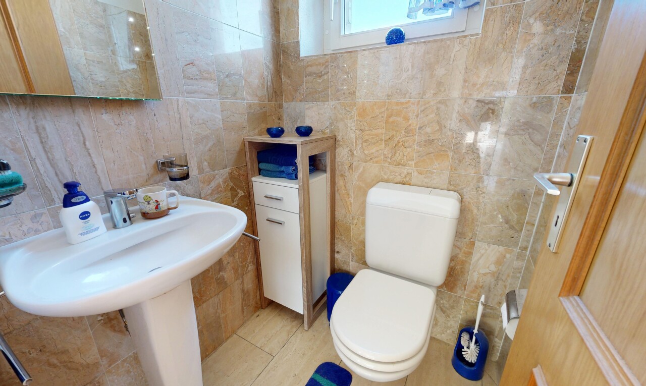 salle de bains avec toilette, tile wall, mur en carrelage, miroir, et light floor