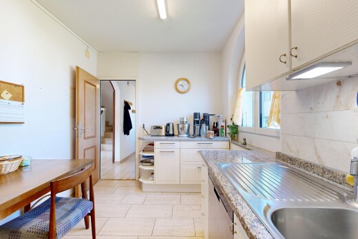 cuisine avec armoires blanches, white cabinets, light countertops, évier, et light floor