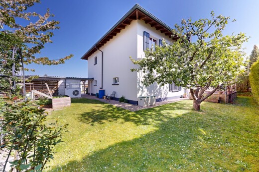 façade avec property visible, bardage en stuc, pelouse, et day time