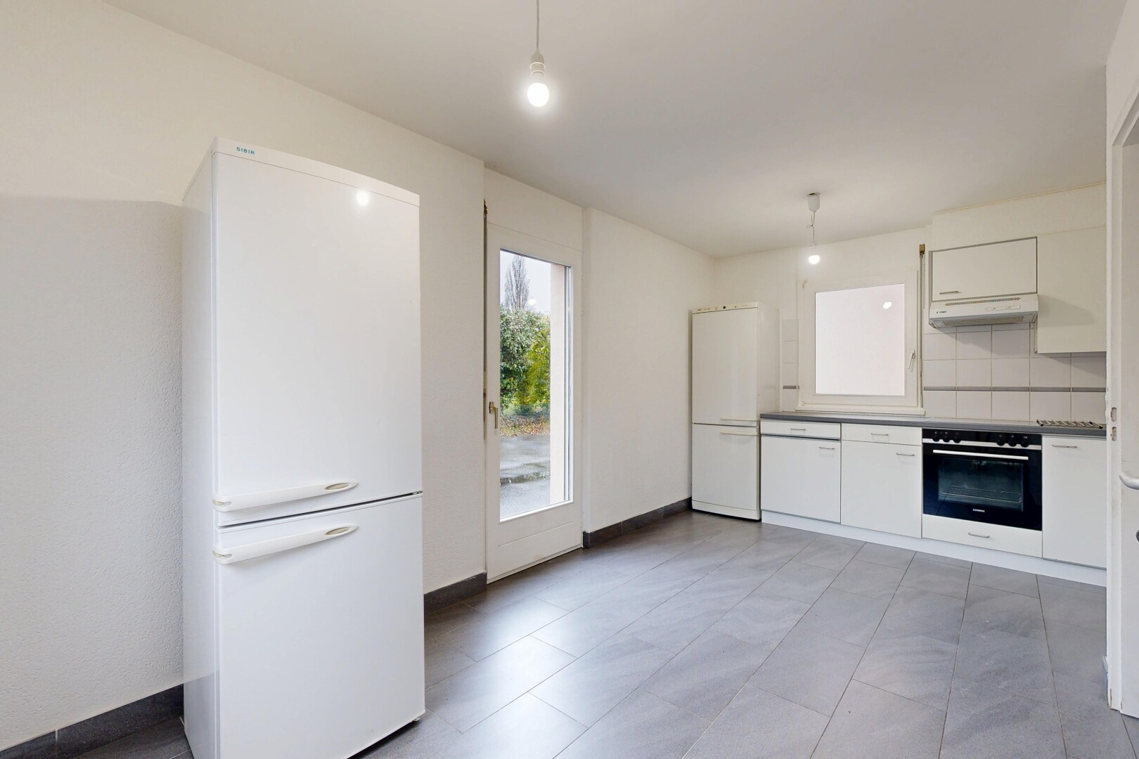 cuisine avec réfrigérateur, white cabinets, armoires blanches, pendant lighting, et éclairage suspendu