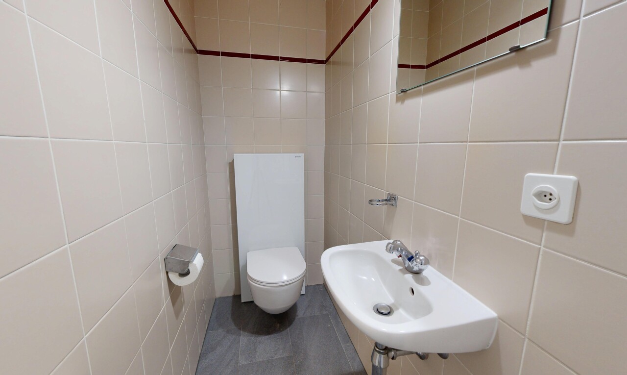 salle de bains avec toilette, évier, inside property, tile wall, et mur en carrelage