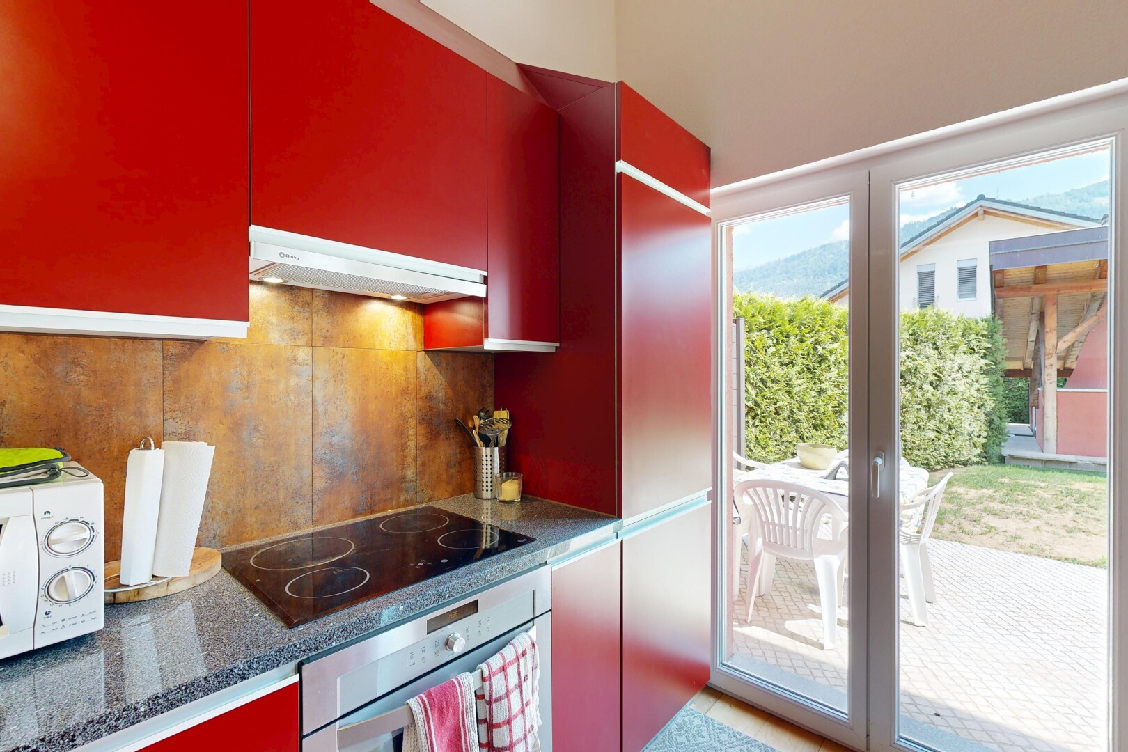 cuisine avec four, hotte, red cabinets, armoires rouges, et micro-ondes