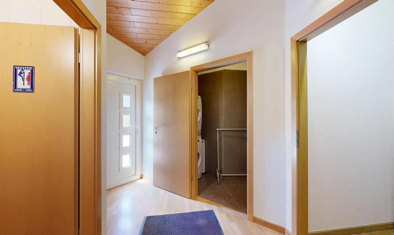 couloir avec inside property, wood ceiling, plafond en bois, drywall, et cloison sèche