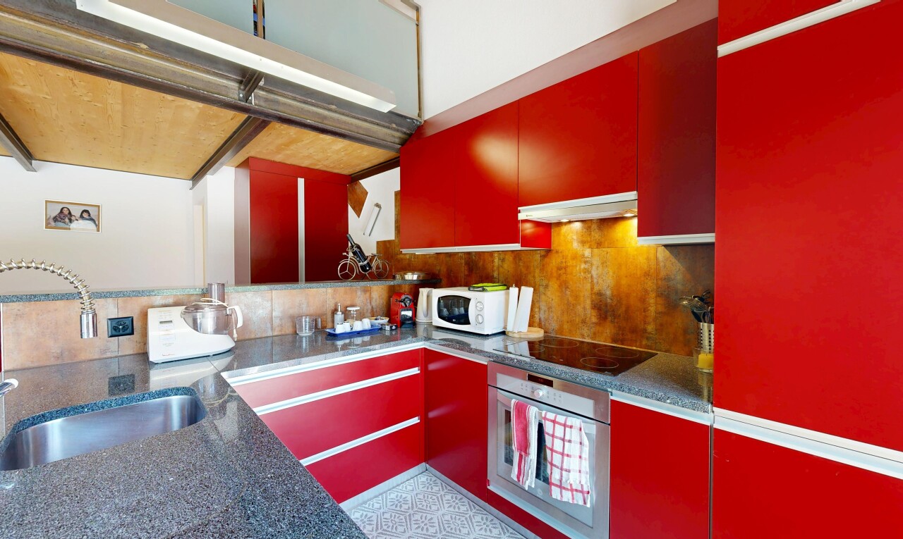 cuisine avec red cabinets, armoires rouges, four, évier, et backsplash