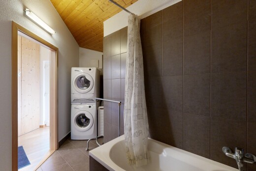 buanderie avec buanderie, lave-linge et sèche-linge superposés, wood ceiling, plafond en bois, et tile floor