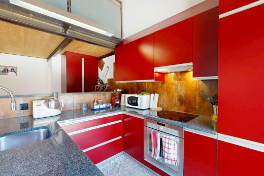 cuisine avec red cabinets, armoires rouges, four, évier, et backsplash