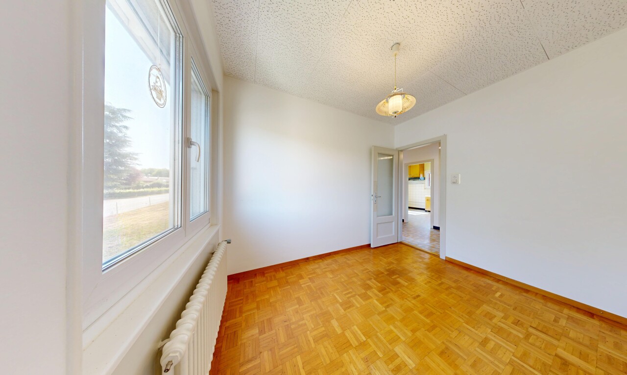 pièce vide avec radiateur, sol en finition bois, wood finish floor, plafond texturé, et textured ceiling