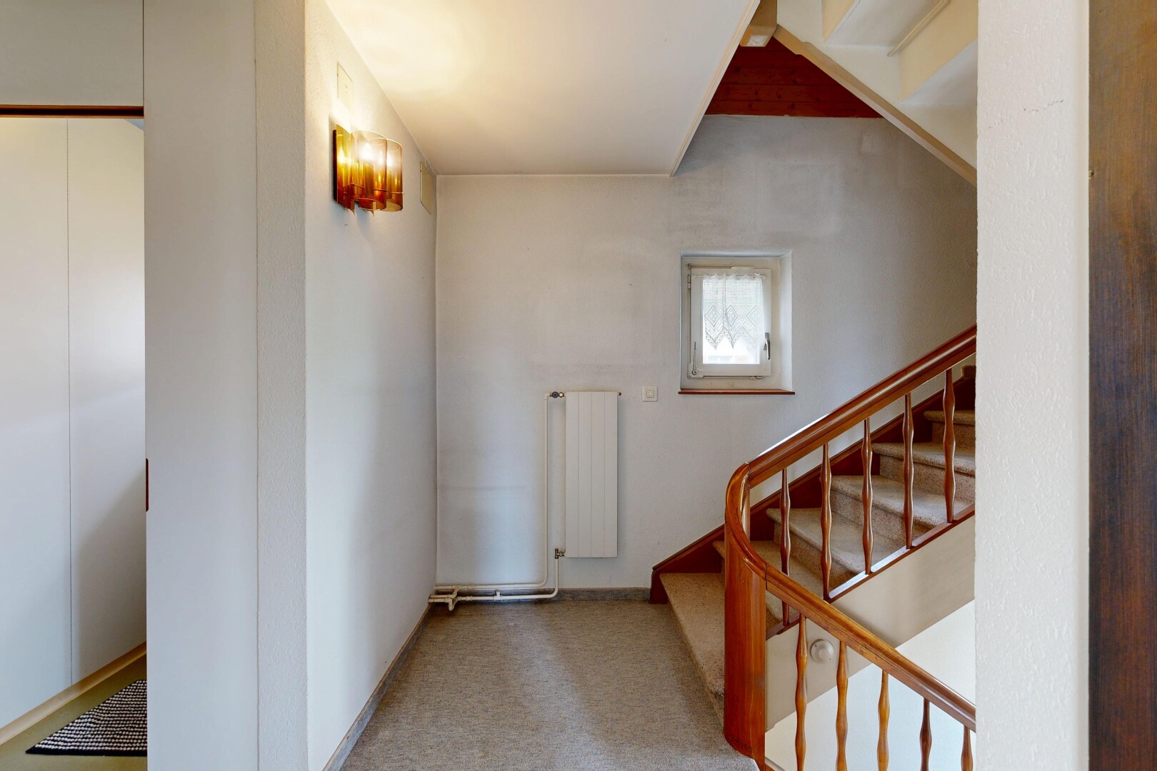 couloir avec inside property, drywall, cloison sèche, radiateur, et natural light