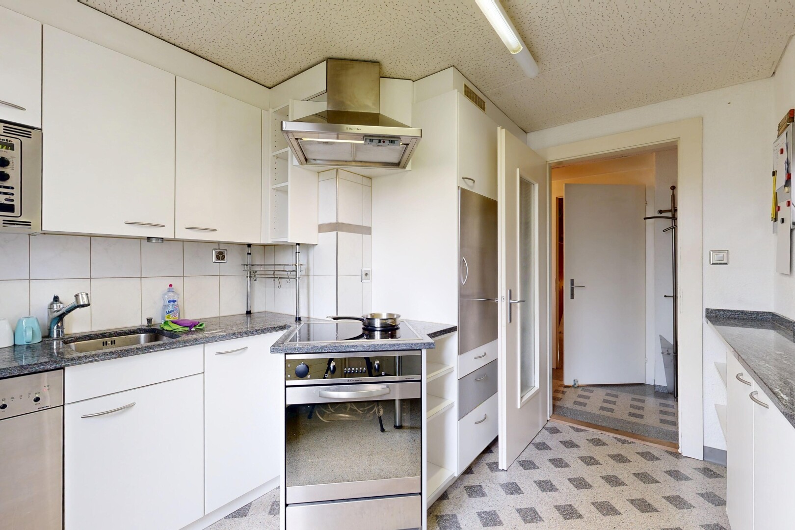 cuisine avec hotte, armoires blanches, backsplash, dosseret, et four