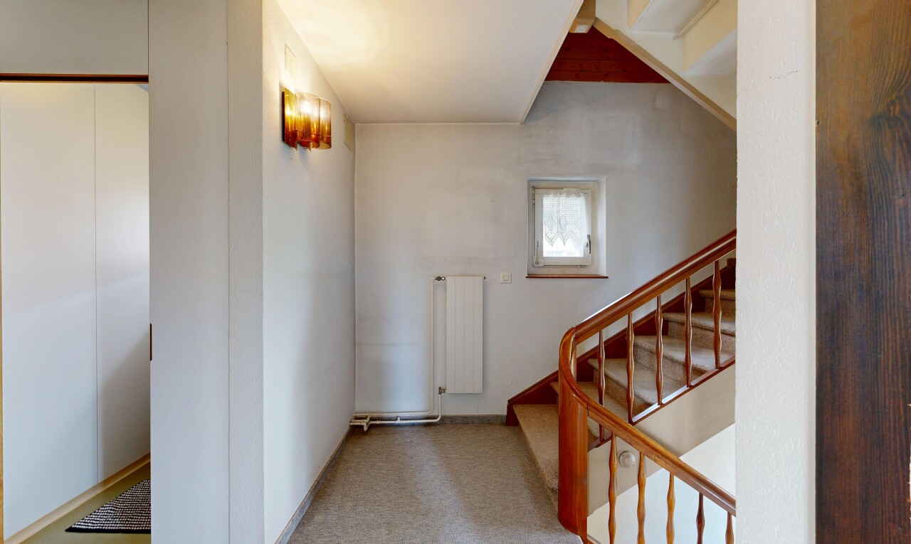 couloir avec inside property, drywall, cloison sèche, radiateur, et natural light