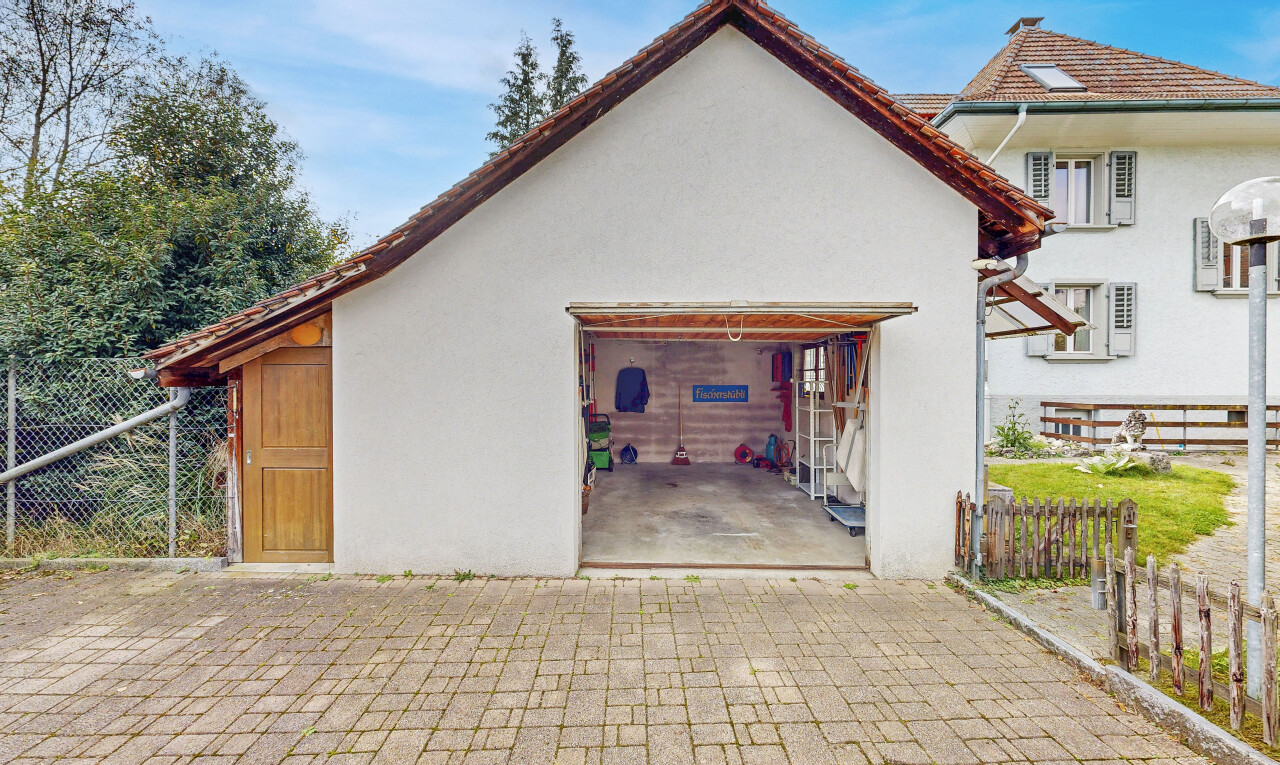 façade avec clôture, bardage en stuc, property visible, terrasse, et garage attaché