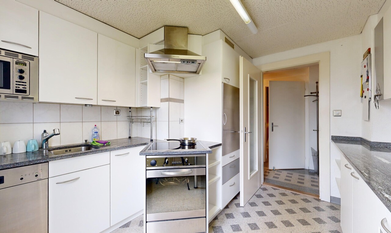 cuisine avec hotte, armoires blanches, backsplash, dosseret, et four