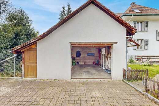 façade avec clôture, bardage en stuc, property visible, terrasse, et garage attaché