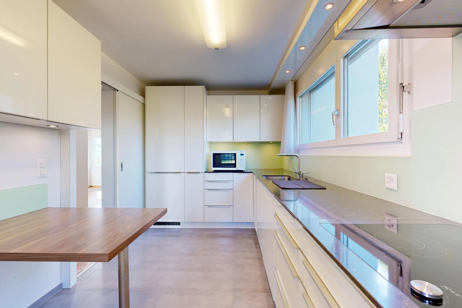cuisine avec hotte, armoires à panneau plat, flat panel cabinets, plaque de cuisson, et light floor
