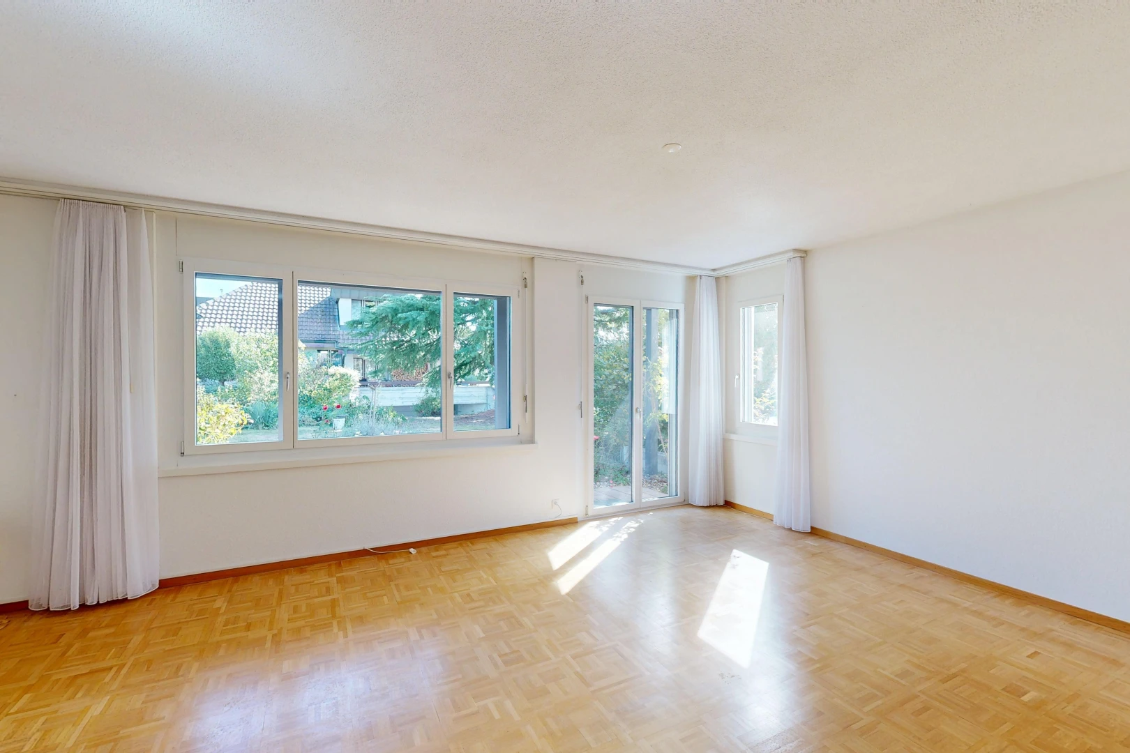 pièce vide avec accès à l'extérieur, drywall, cloison sèche, lumière naturelle, et wood finish floor