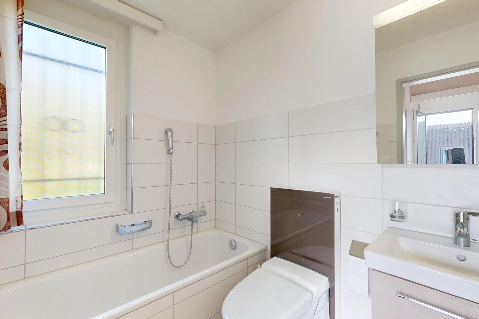 salle de bains avec bain, salle de bain complète, miroir, lavabo (ou coiffeuse selon le contexte), et toilette