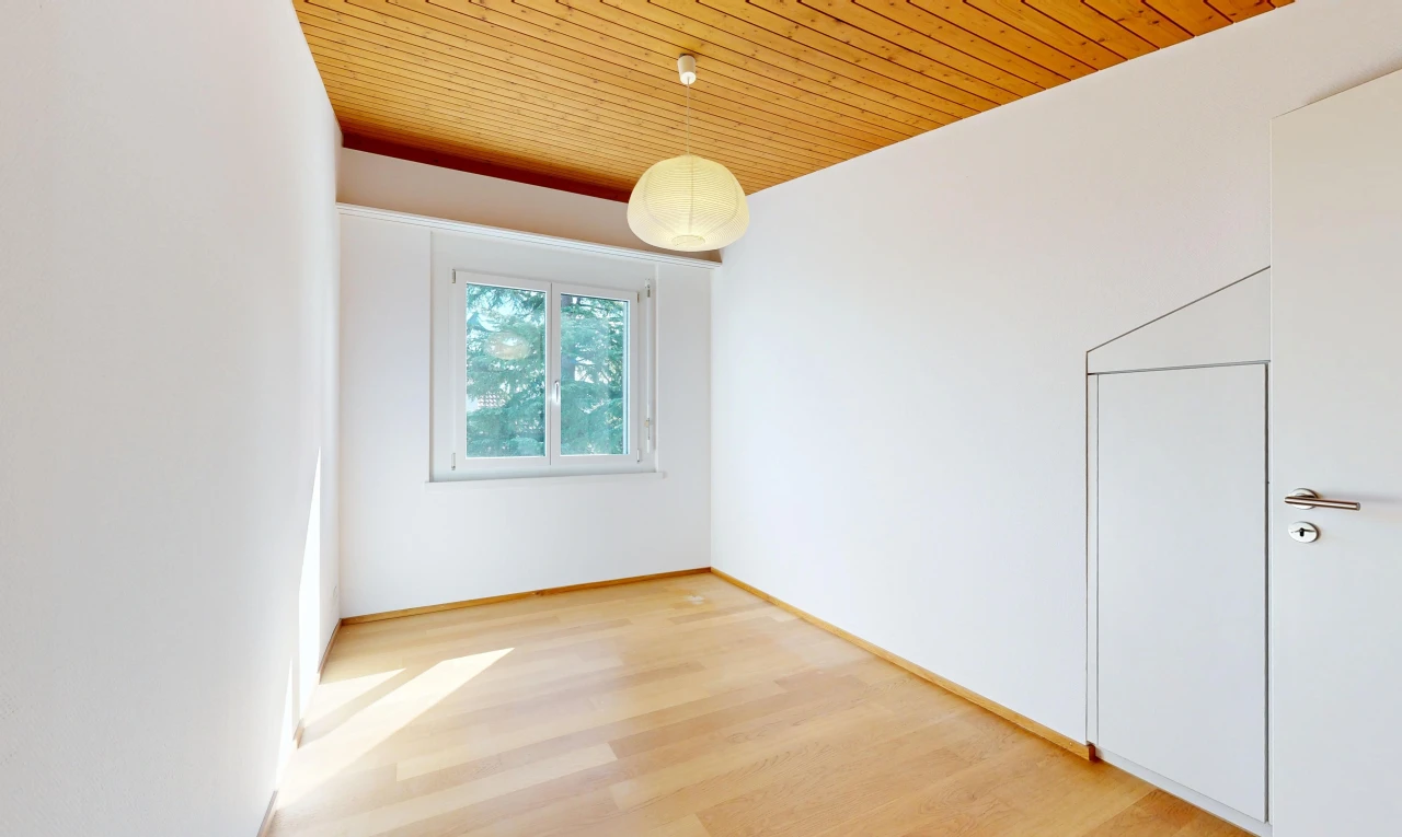 pièce vide avec wood ceiling, plafond en bois, éclairage suspendu, drywall, et cloison sèche