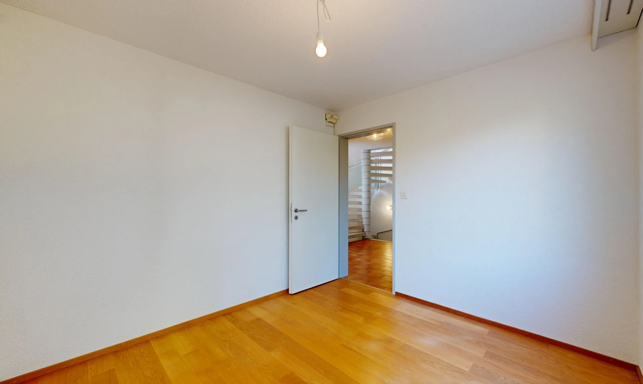 pièce vide avec wood finish floor, sol en finition bois, drywall, cloison sèche, et escaliers