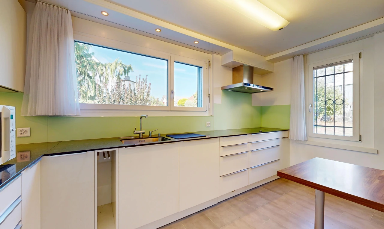 cuisine avec hotte, flat panel cabinets, armoires à panneau plat, light floor, et dark countertops