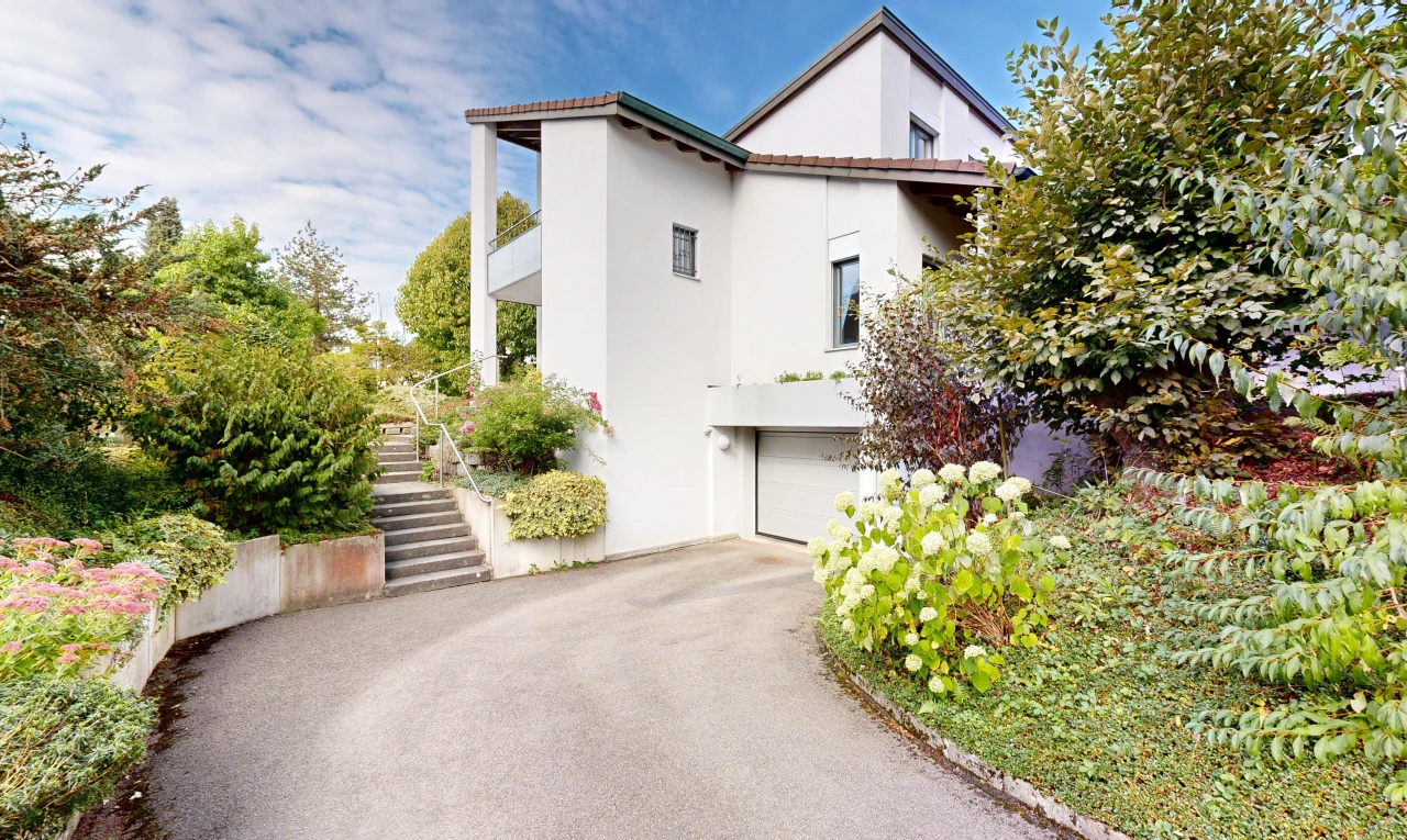 façade avec escaliers, bardage en stuc, garage intégré, allée, et property visible