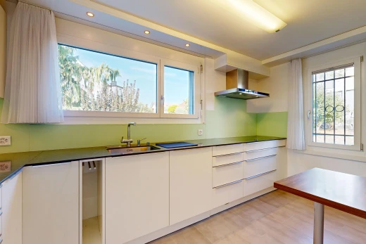 cuisine avec hotte, flat panel cabinets, armoires à panneau plat, light floor, et dark countertops