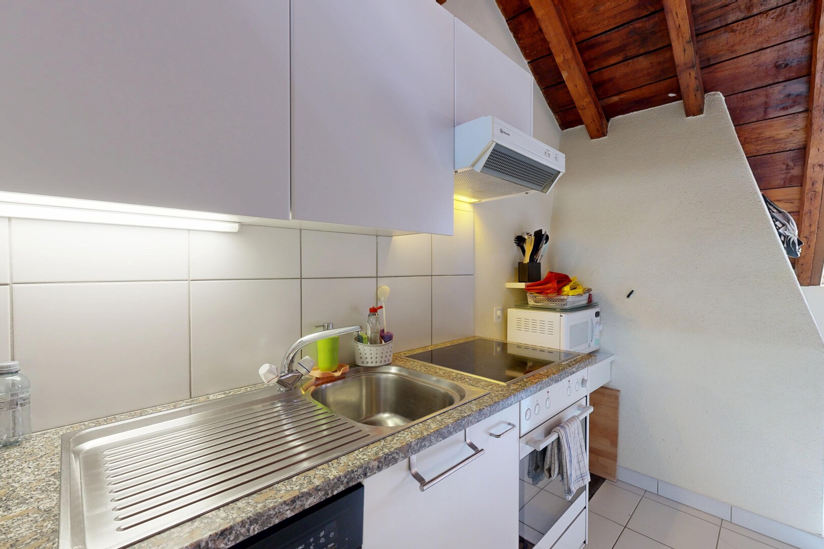 cuisine avec hotte, plafond à poutres, beamed ceiling, dosseret, et backsplash