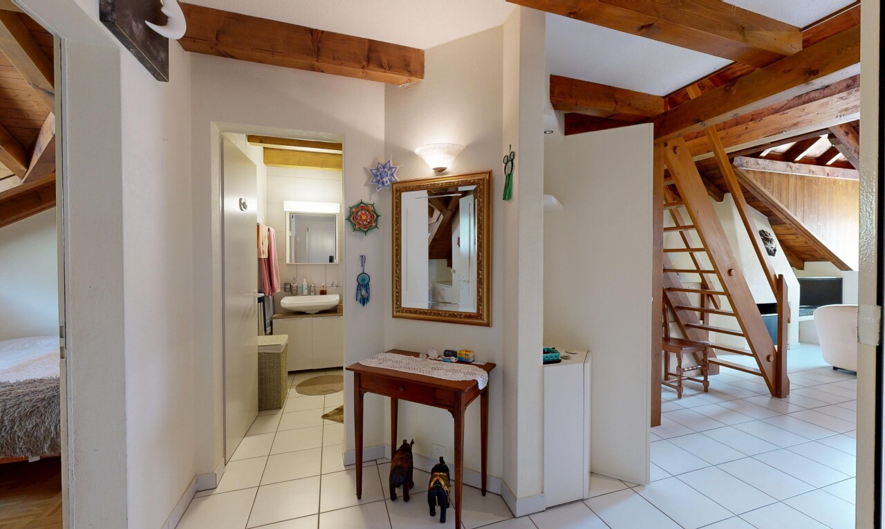 couloir avec escaliers, beamed ceiling, plafond à poutres, drywall, et cloison sèche
