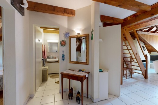 couloir avec escaliers, beamed ceiling, plafond à poutres, drywall, et cloison sèche