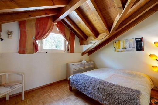 chambre avec vaulted ceiling, plafond voûté, wood finish floor, sol en finition bois, et beamed ceiling