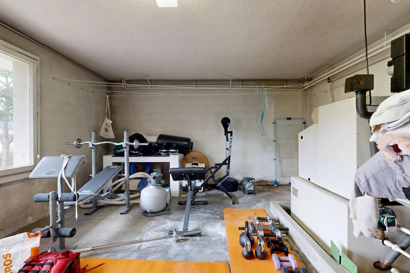 gym avec lumière naturelle, inside property, sol en béton, et concrete floor