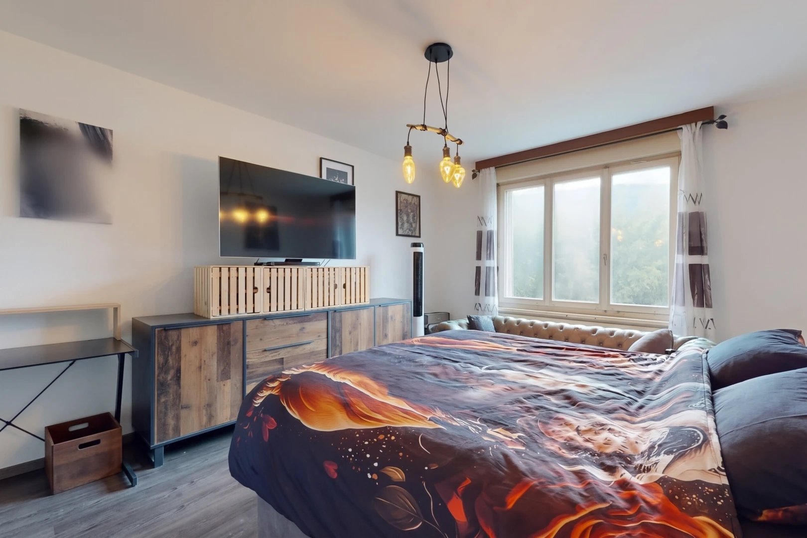 chambre avec télévision, cloison sèche, drywall, sol en finition bois, et wood finish floor