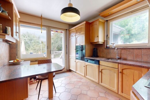 cuisine avec arched cabinets, armoires en arc, light floor, dark countertops, et accès à l'extérieur