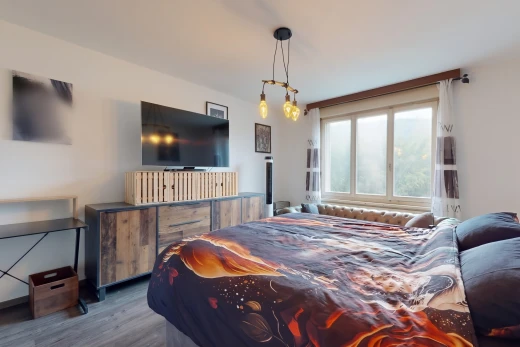chambre avec télévision, cloison sèche, drywall, sol en finition bois, et wood finish floor