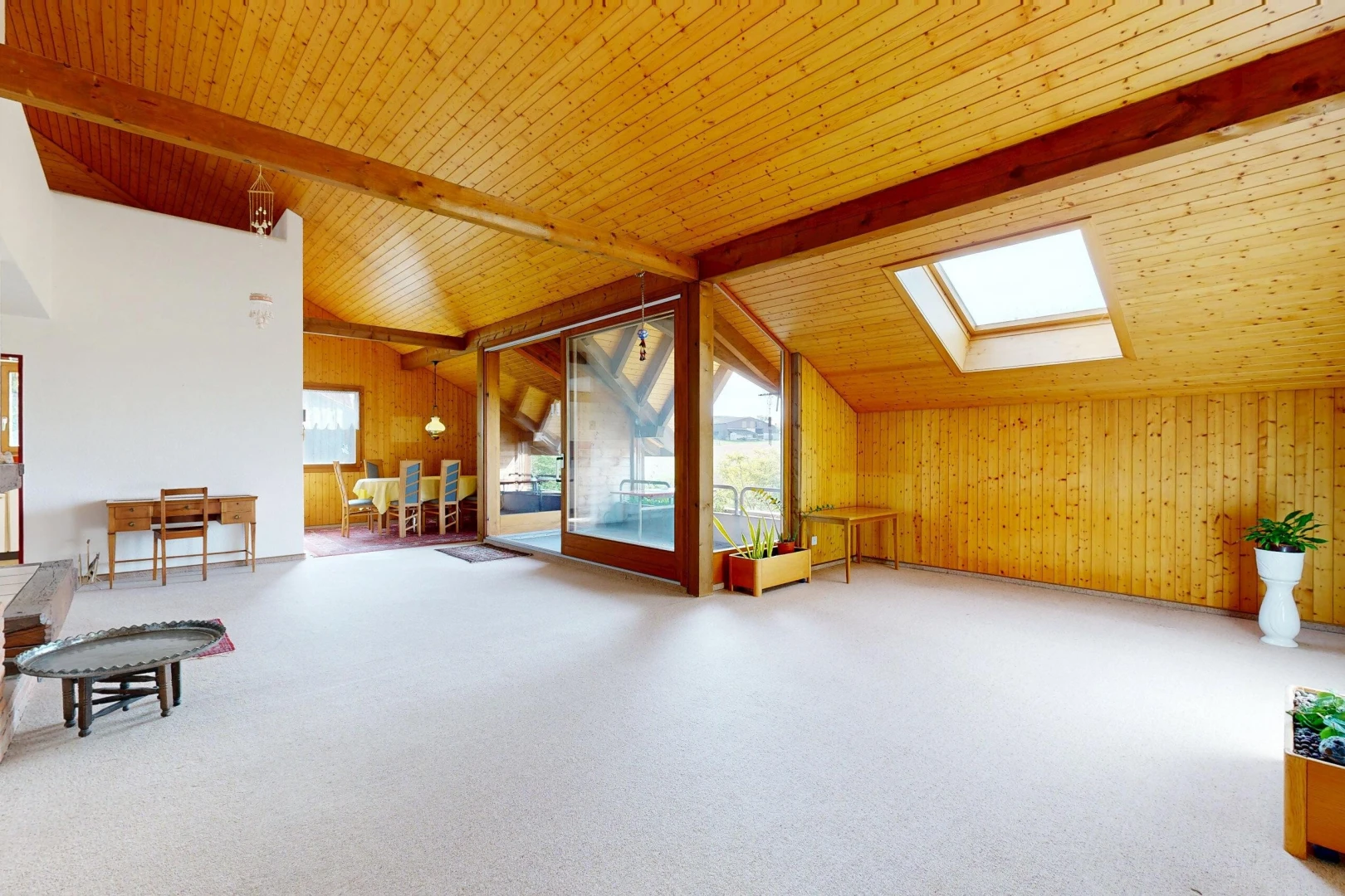 pièce vide avec vaulted ceiling, plafond voûté, puits de lumière, accès à l'extérieur, et beamed ceiling