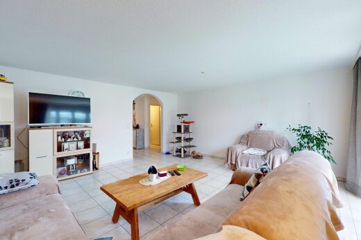 wohnzimmer mit gewölbte gehwege, fernseher, inside property, drywall, und gipskartonwand