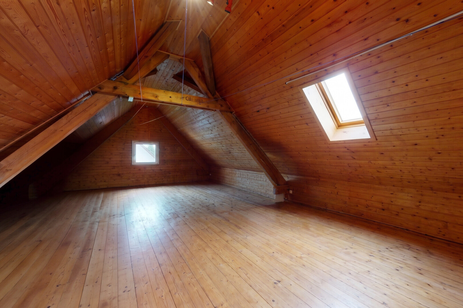 pièce vide avec puits de lumière, plafond cathédrale, cathedral ceiling, hardwood floor, et sol en finition bois