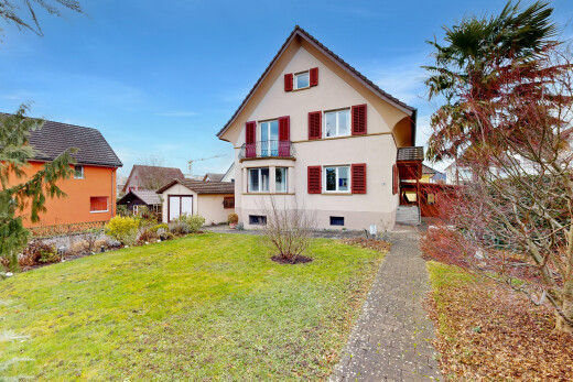façade avec balcon, bardage en stuc, pelouse, property visible, et day time