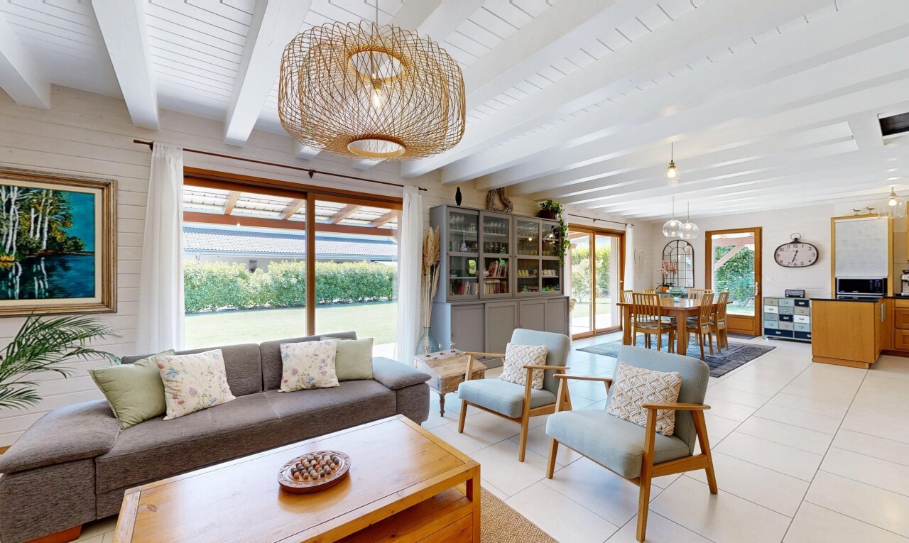 wohn- / esszimmer mit bemerkenswerter kronleuchter, inside property, beamed ceiling, balkendecke, und natural light