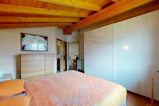zimmer / schlafzimmer mit inside property, wood finish floor, holzfußboden, vaulted ceiling, und dachschräge