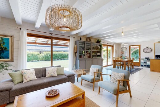 living / dining area featuring hanging lights, beamed ceiling, and light tile patterned flooring
