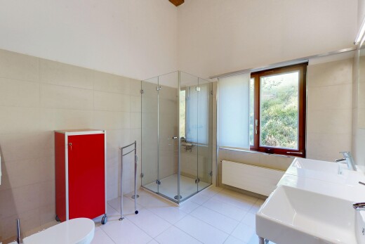 salle de bains avec tile wall, mur en carrelage, douche, inside property, et évier